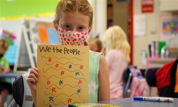 Girl holds up Constitution craft